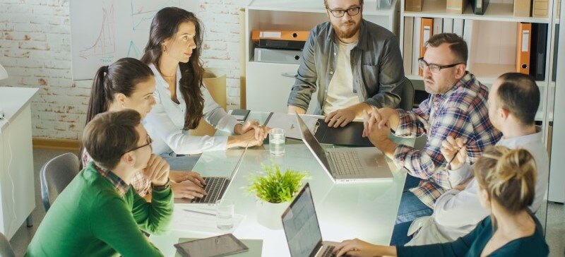 group of people in a company who are strategic planning in a conference room around a table