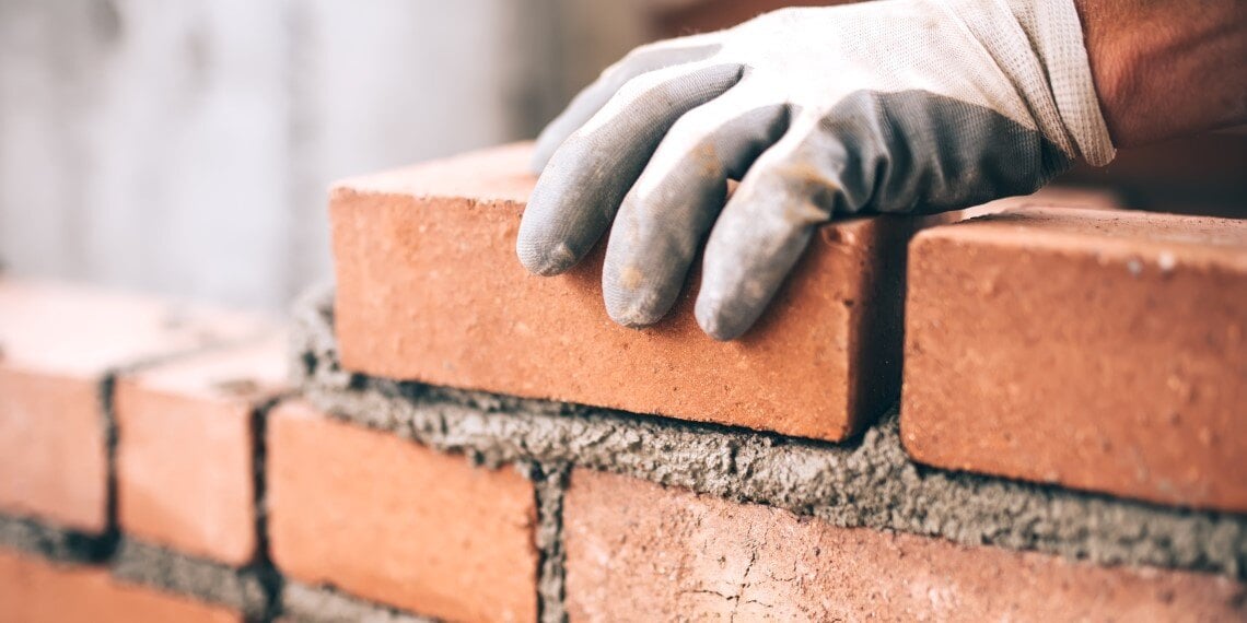 Man laying bricks for a building project that was funded by a capital campaign