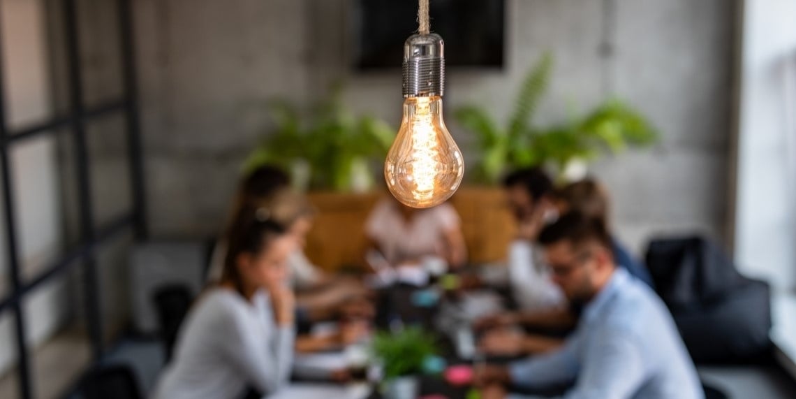 How to launch and grow a major gifts program visual of a light bulb and people working at a table