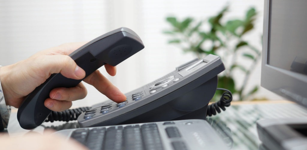Supporting donors for nonprofit fundraising image of person's hand dialing a digital phone