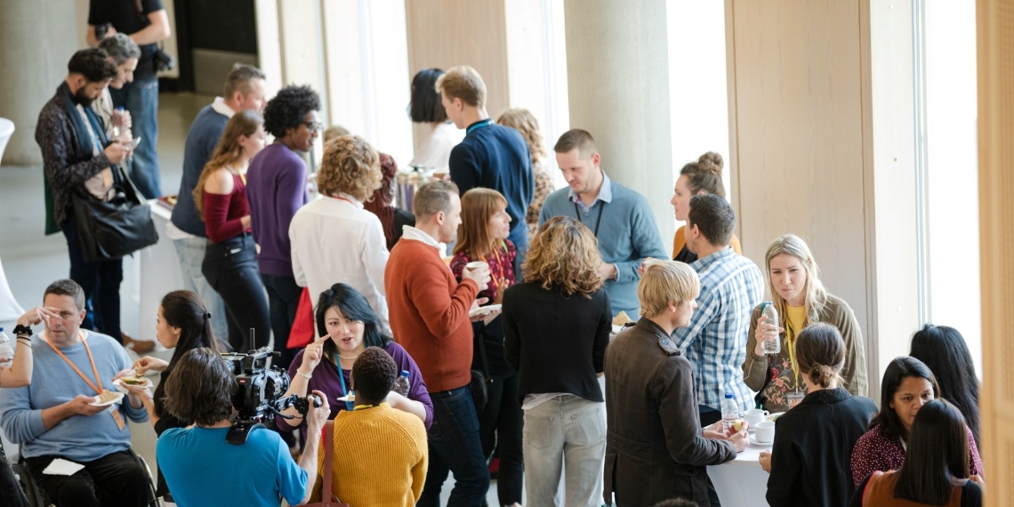 Can't miss collaborative nonprofit conferences illustrated by a room full of people networking