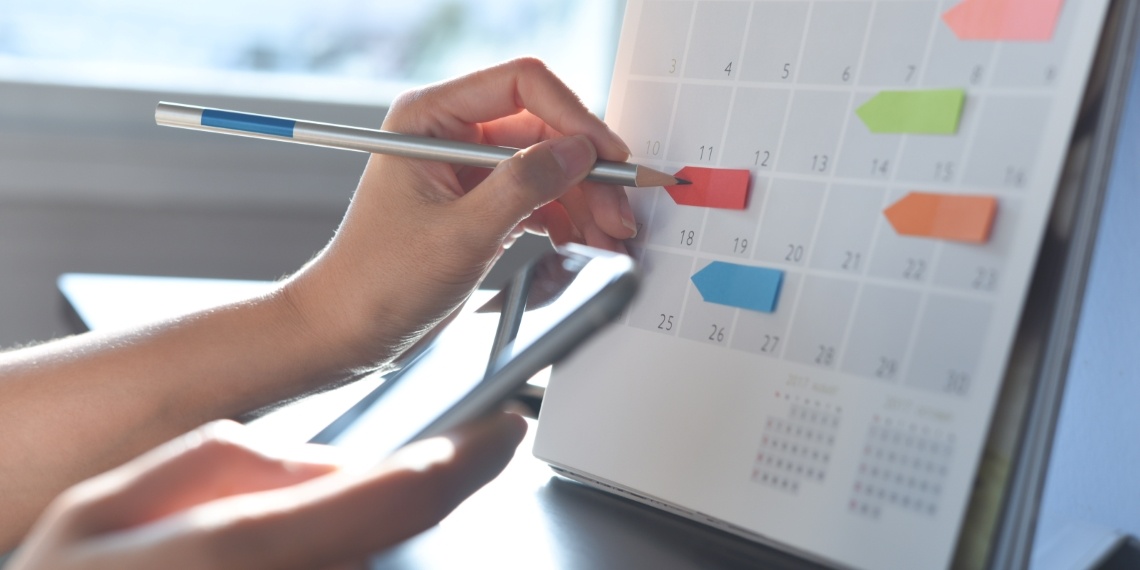 End of year fundraising push illustrated by a calendar marked being marked with colorful tabs and a pen